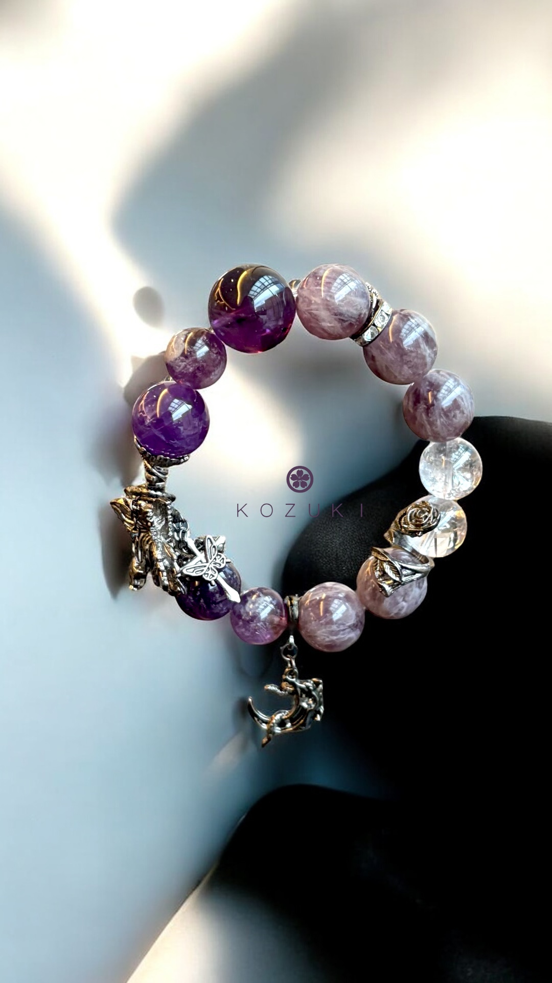 Close-up of amethyst moon charm bracelet with silver butterfly detail
