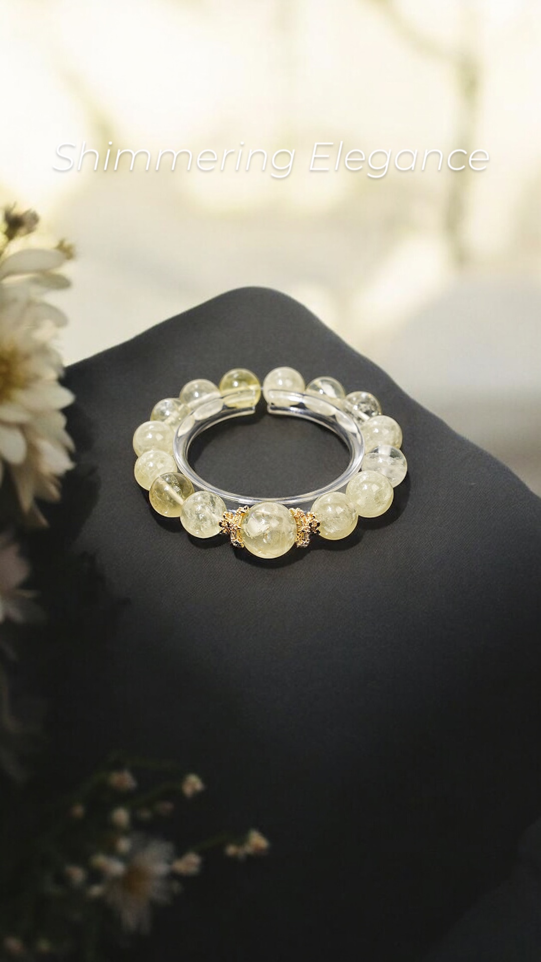 Gleam no Hikari crystal bracelet with citrine and gold accents on soft black cloth with bright light