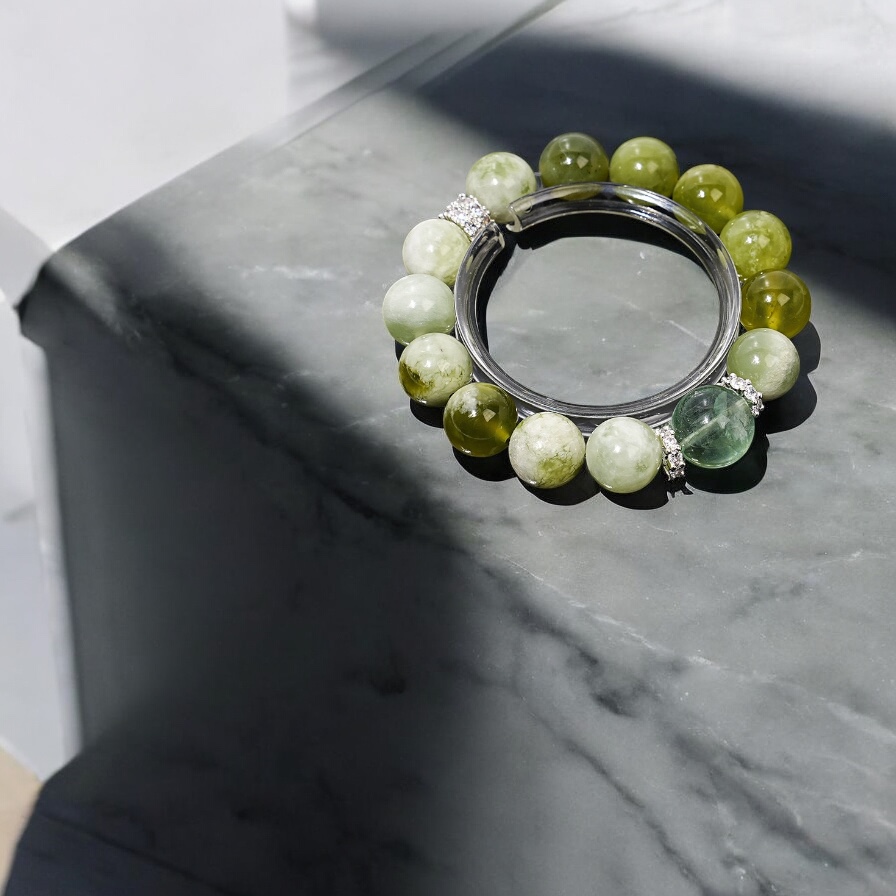 Green jade bamboo bracelet with prasiolite beads and silver accents on dark stone background