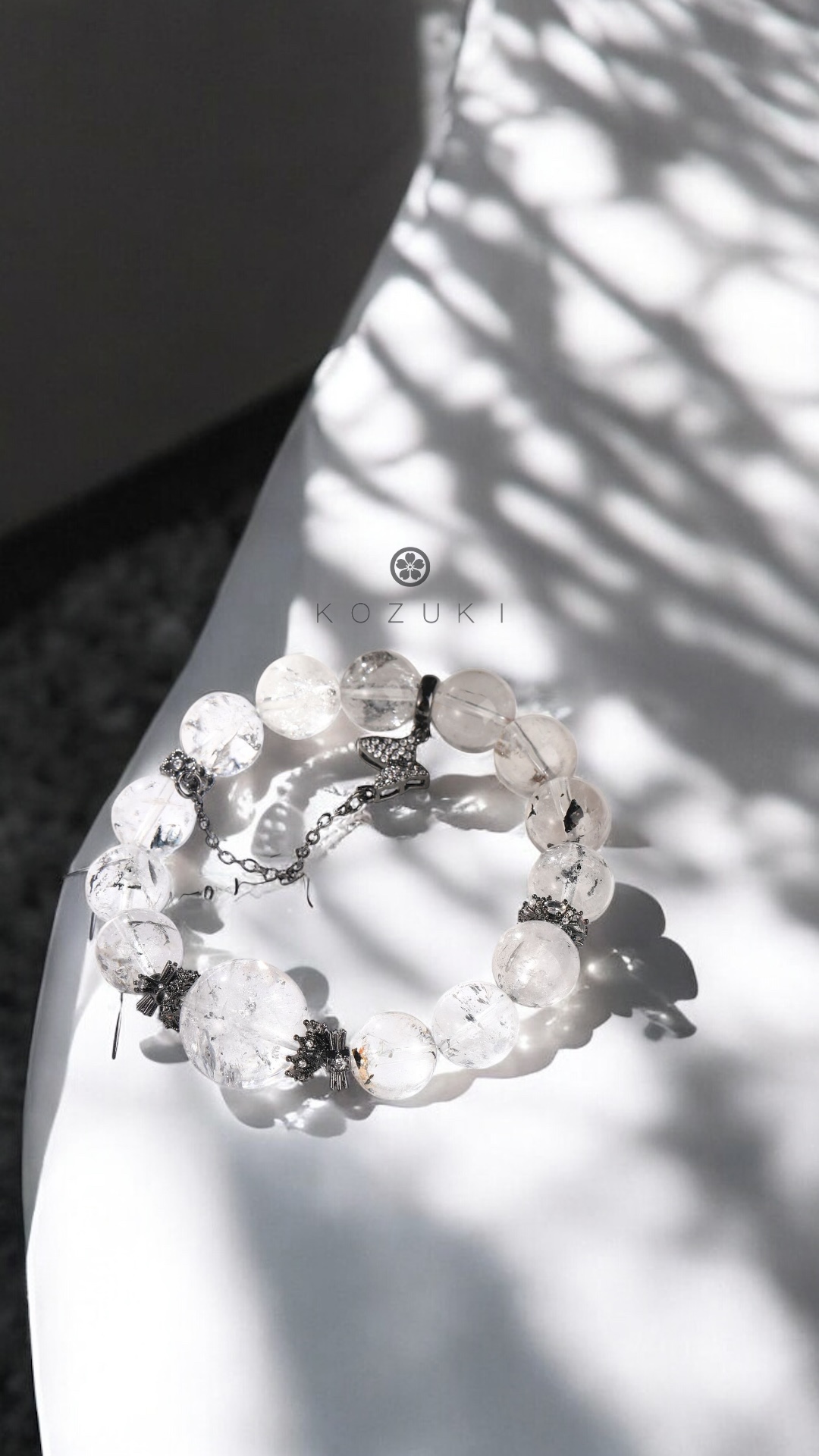 white crystal bracelet made of phantom quartz with black crown details under soft light